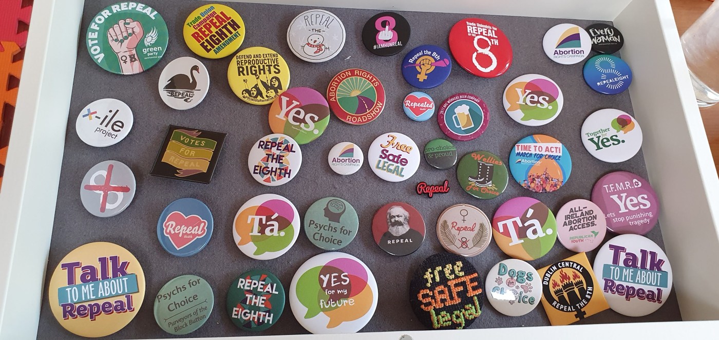 A shadow box with a large number of badges displayed. They all relate to the campaign to repeal the 8th and to abortion rights